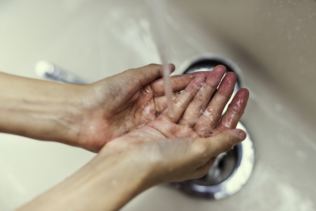 Washing your hands with water and your usual emollient soap substitute should be adequate. Emollient helps remove the virus from hands during the washing process, and serves the same cleansing purpose as soap.