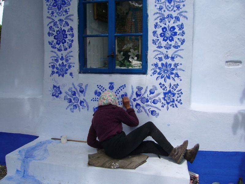 Once retired Anežka Kašpárková, instructed by a woman named Maňák, became proficient in arranging decorations on houses.