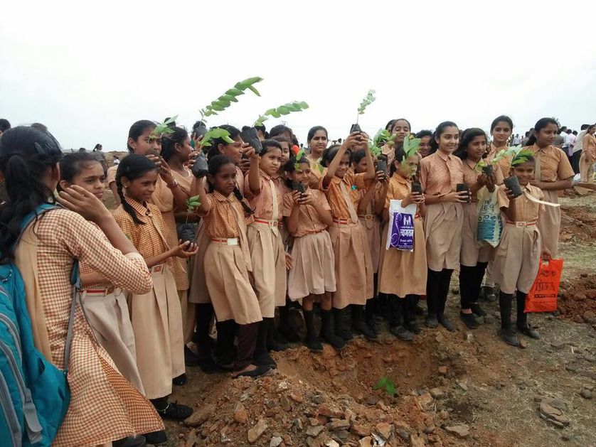 Schoolkinderen poseren met hun klein bomen in spe.