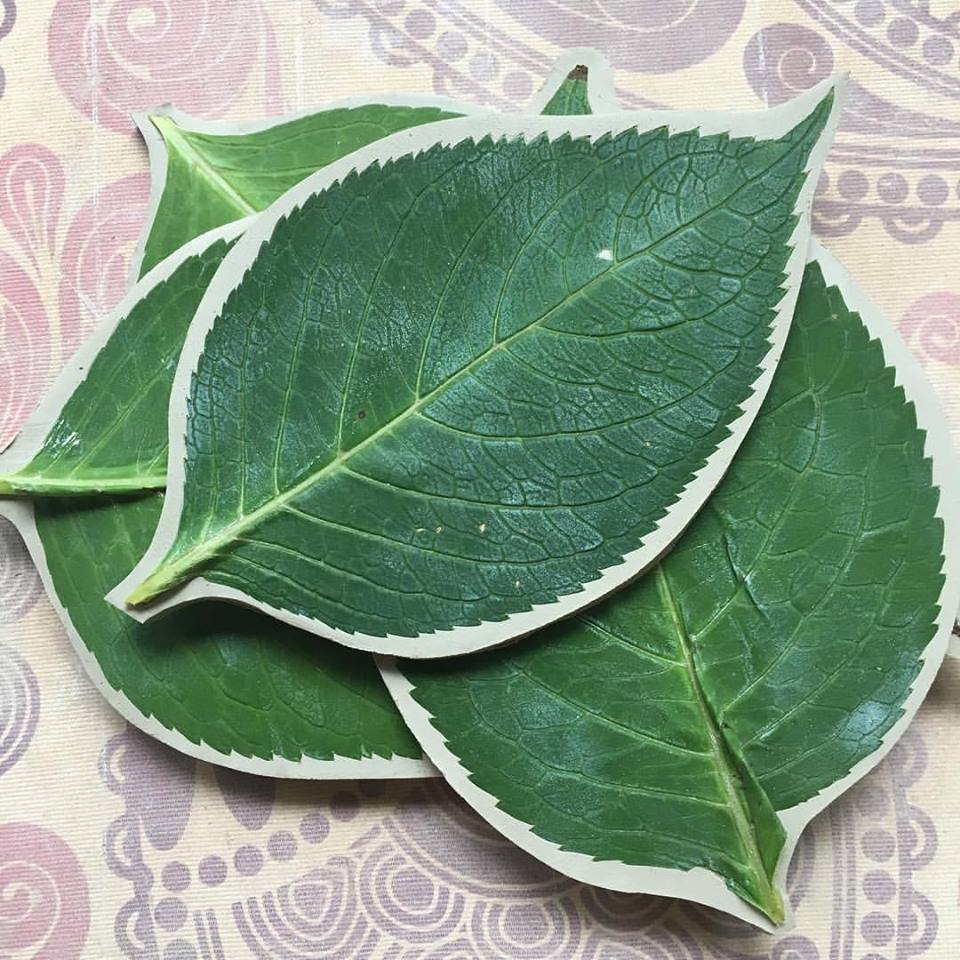 Fresh-cut leaves are pressed firmly into the soft clay to leave (see what I did there?) what will be a perfect impression in the finished dish.