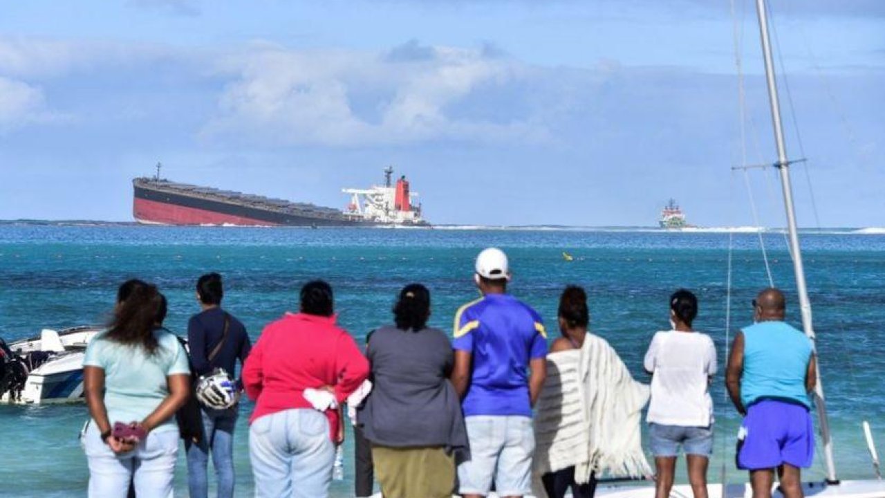 Anxious Mauritians use their hair and stockings to mop up leaking oil from a stranded ship