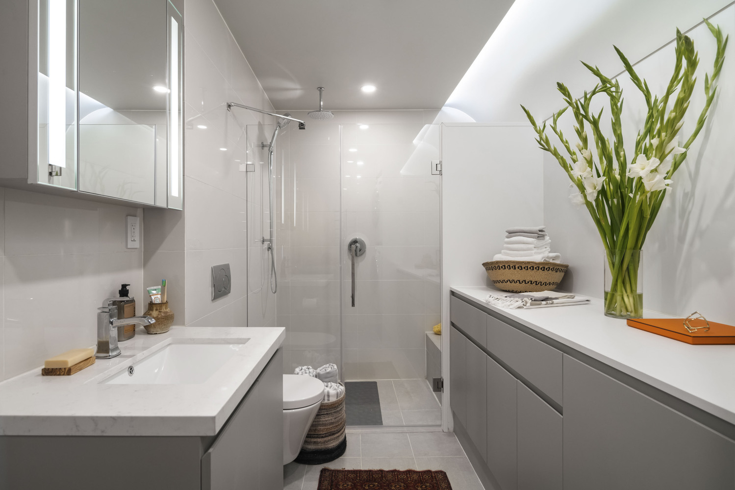 Designer selected plumbing fixtures. Designer selected ceramic tile in shower. Elegant mirrored medicine cabinet. Custom cabinetry. Quartz countertops. Vanity.