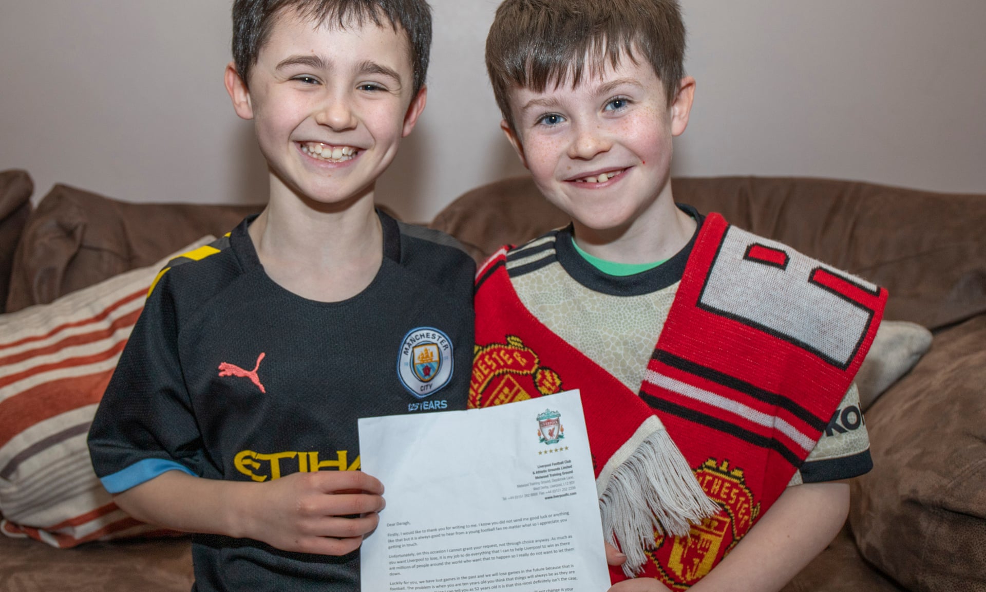 Manchester United fan, Daragh Curley (right), and his brother Dylan, a Manchester City fan, with his letter from Liverpool’s  Jürgen Klopp.