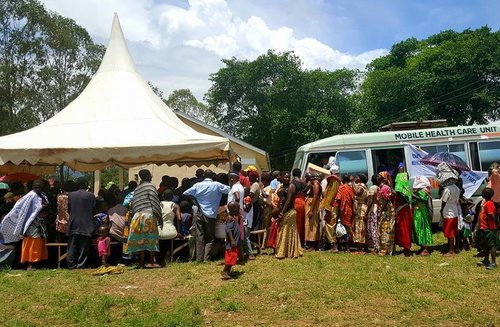 People gather around one of the mobile healthcare units