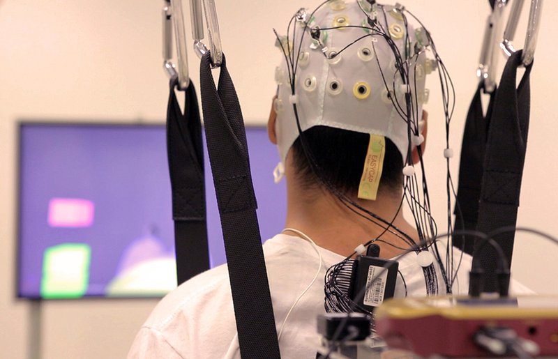 Middels een muts van elektroden worden signalen van de hersenen omgezet in beweging van het exoskeleton.