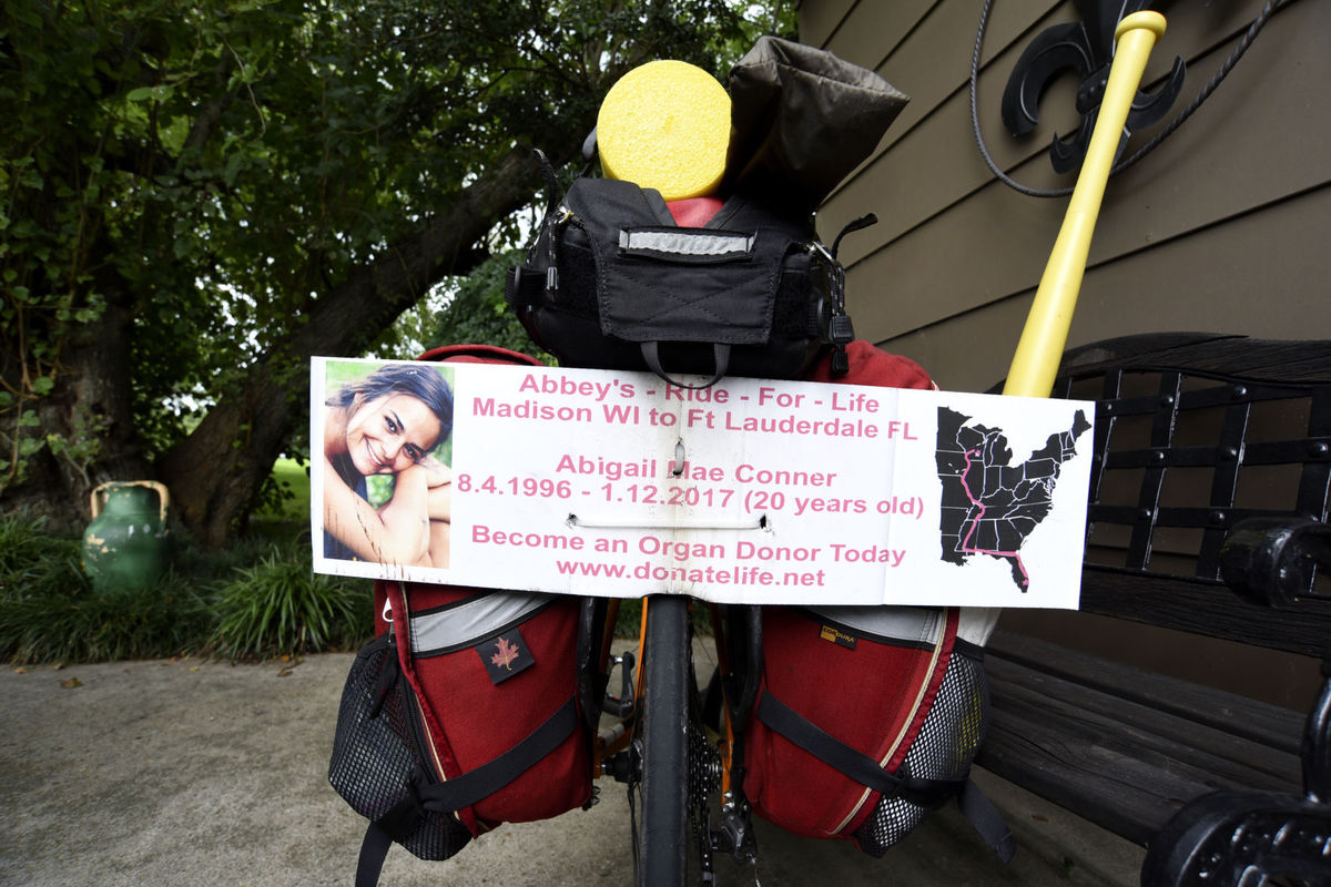 A sign on the back of Bill's bicycle explains why he is riding 2,600 miles from Madison to Fort Lauderdale, Florida, where his daughter Abbey's organs were donated in January.