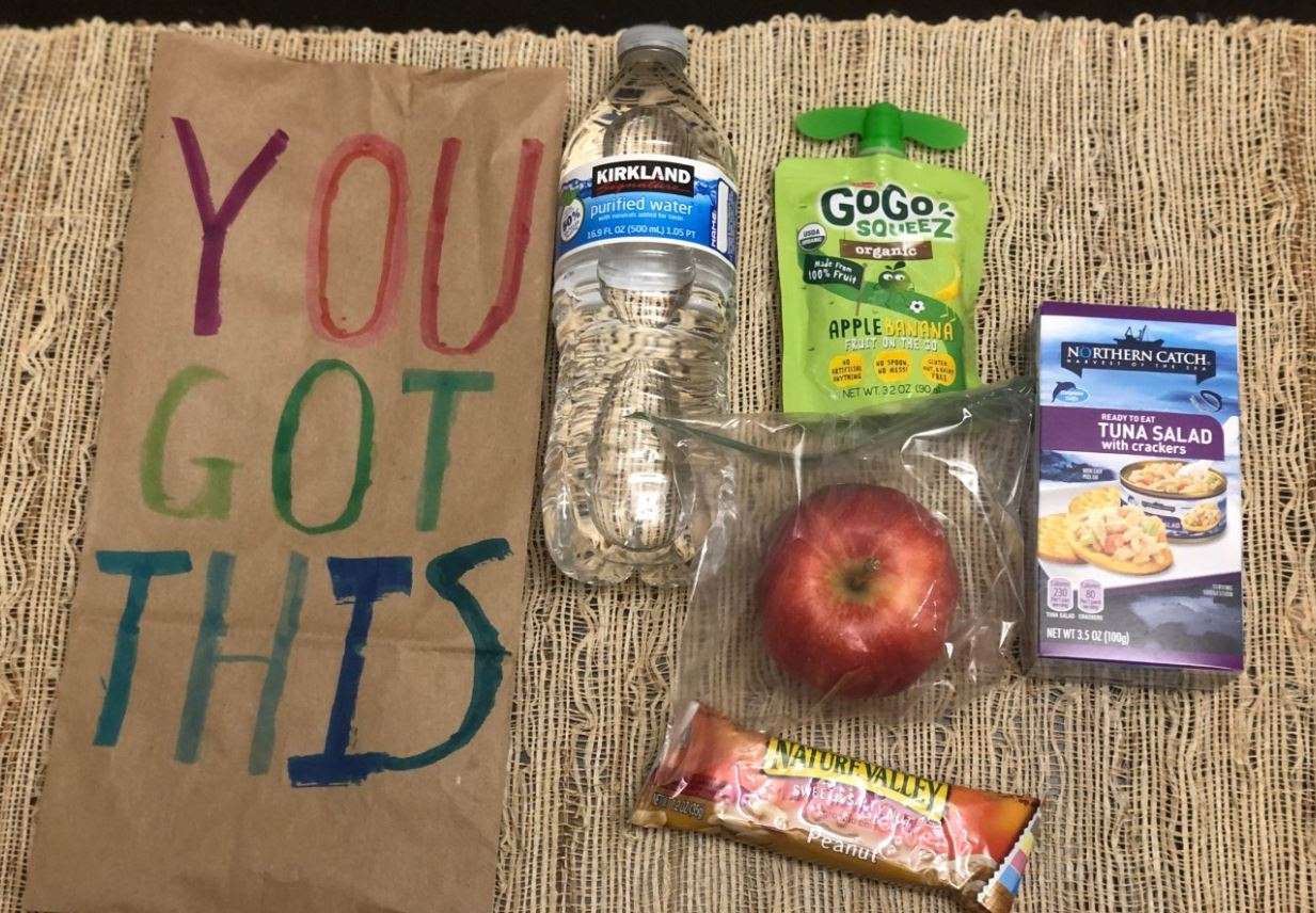Those making donations are asked to bring packed meals containing 1 bottle of water, 2 tangerines or 1 apple in a zipped sandwich bag, 1 applesauce cup or tuna pouch, and 1 packaged granola bar. The contents should be inside a brown paper bag with a positive message written on it.