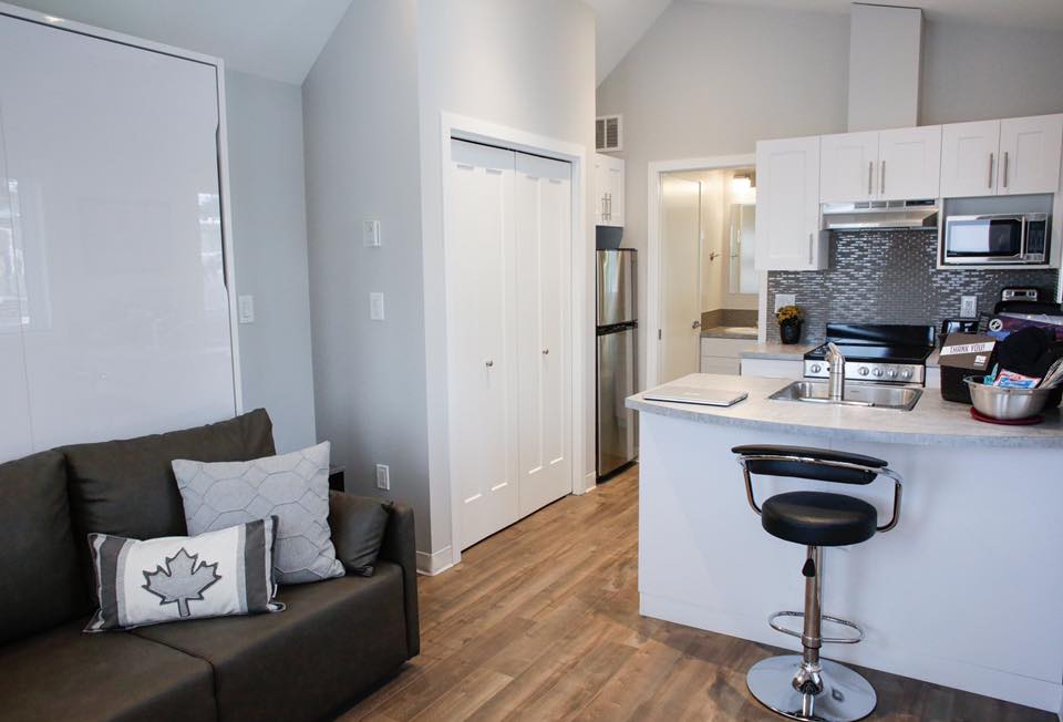 Each of the 15 tiny homes includes a full kitchen, a breakfast bar and workstation, a full bathroom, and a living area with a sofa and a Murphy bed.