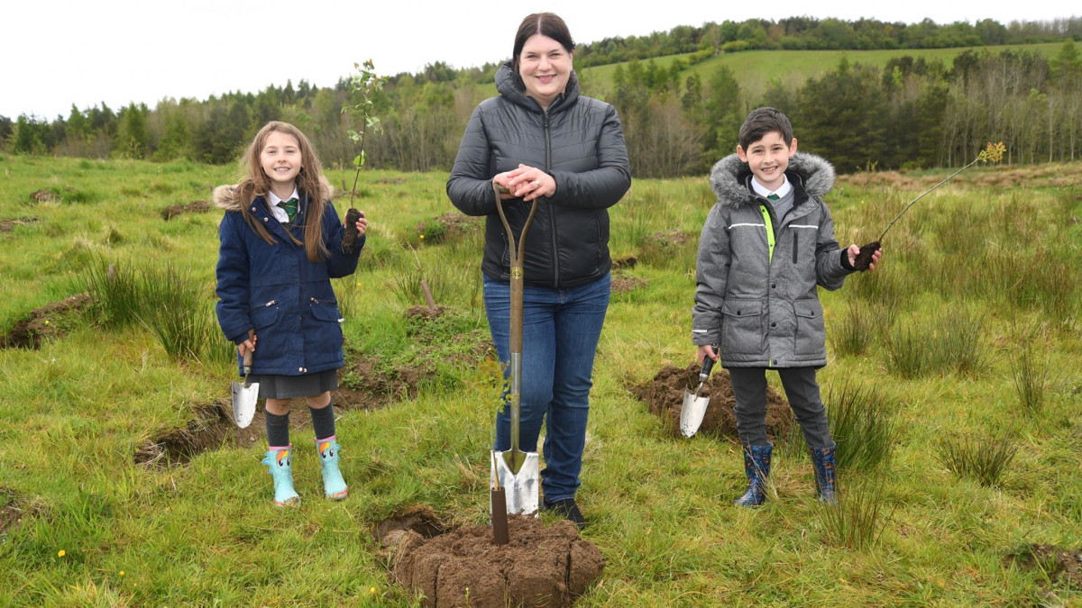 La concejala Susan Aitken, líder del ayuntamiento de Glasgow y presidente del gabinete de la región de la ciudad de Glasgow, y escolares, como se puso en marcha el plan forestal urbano.