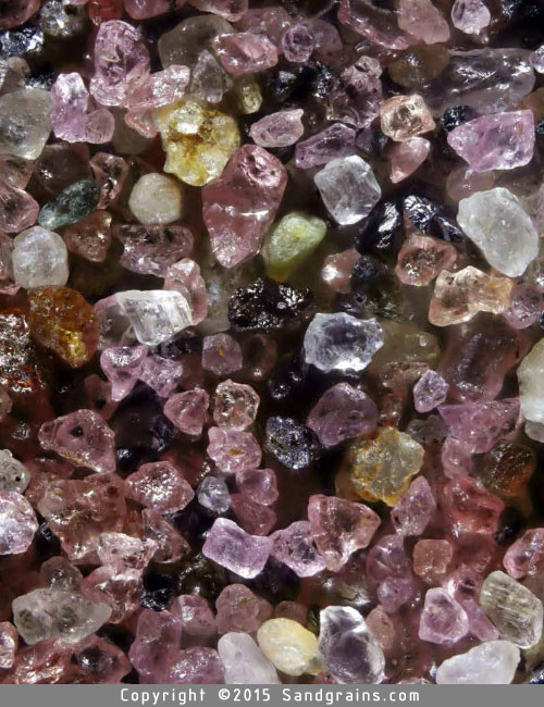 The beach at Plum Island, Rowley, Massachusetts, the northernmost barrier island in the United States, gets its pink colour from garnets in the sand. As garnet is denser than most other sand grains, it gets left behind as the waves sweep the less dense material farther away. Magnified 60 times.